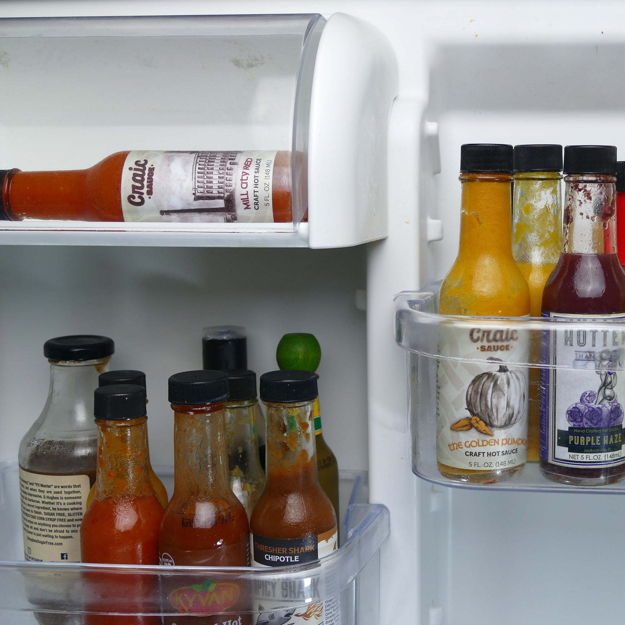 collection of hot sauces in fridge